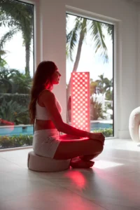 woman meditating with red light therapy for recovery and stress relief